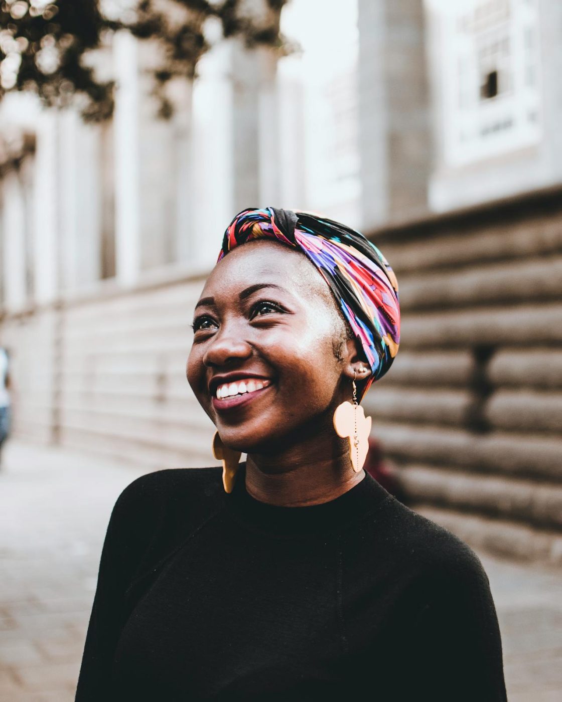 african american woman smiling and looking at the clouds after her lasik procedure