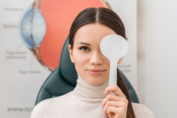 obscured view of young female patient getting eye test in clinic