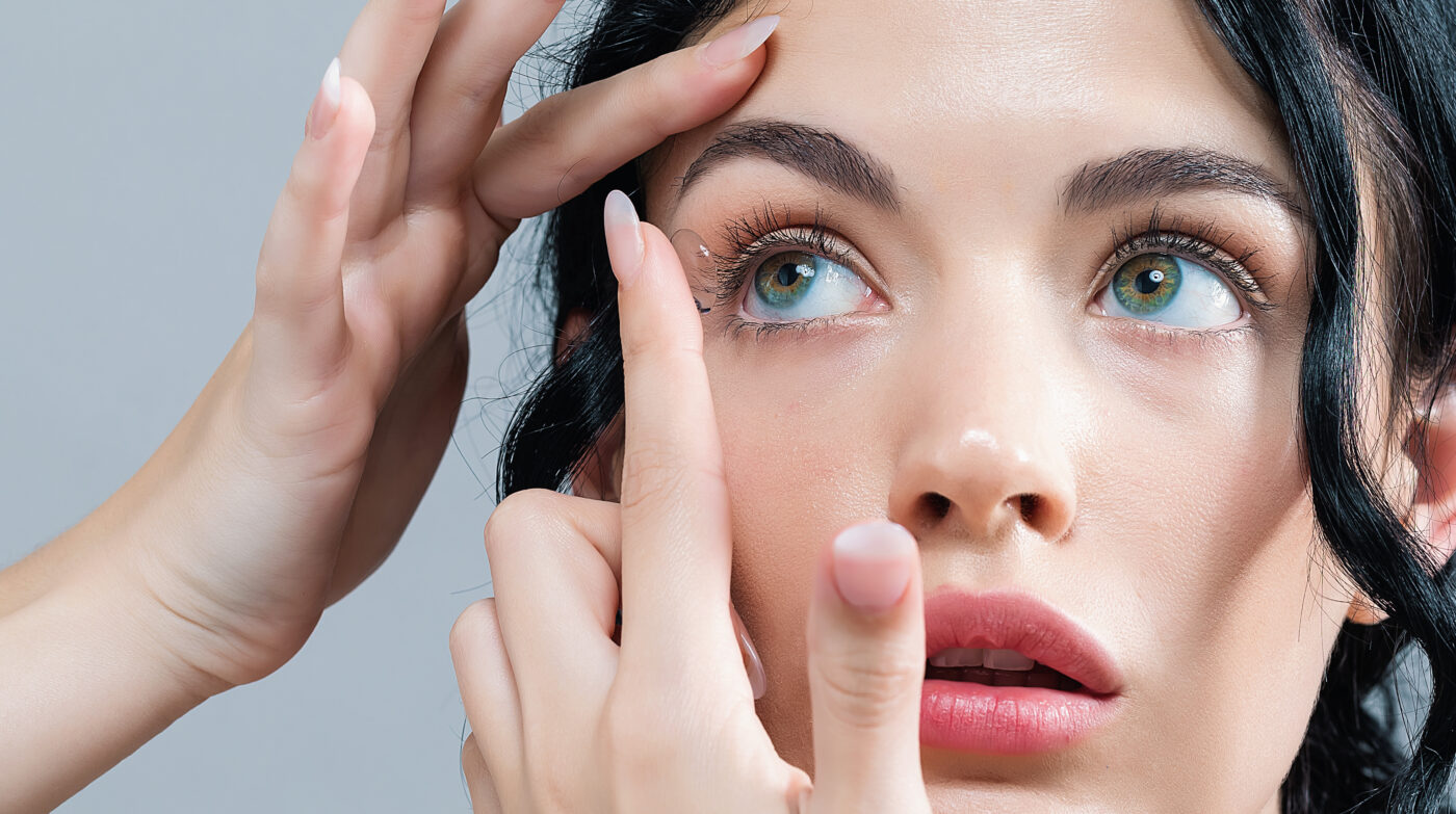Woman inserting contact lens